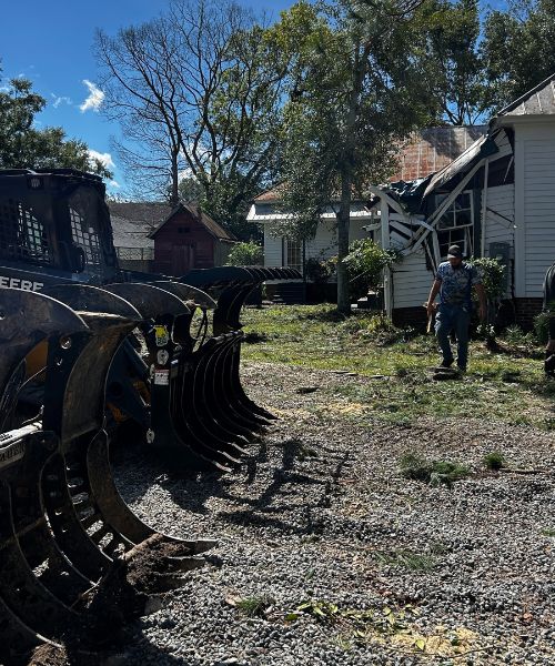 A man standing next to a tractor in a yard